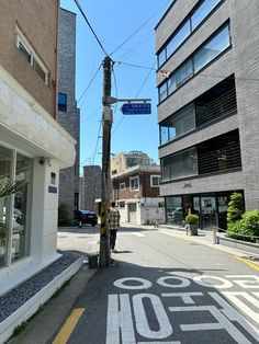 an empty city street with no cars or people on the road and buildings in the background