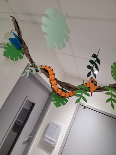 an office door decorated with paper cutouts and jungle animals hanging from the ceiling above it