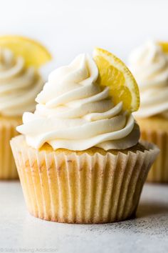 three cupcakes with frosting and a lemon slice on top