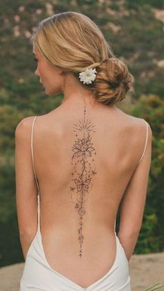 the back of a woman's body with tattoos on it