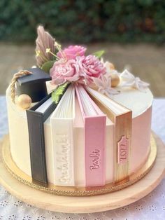 a cake decorated with books and flowers on a table