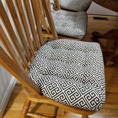 a wooden rocking chair with black and white patterned seat cover