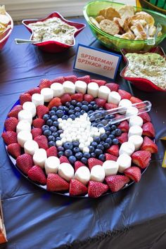 a table topped with plates and bowls filled with desserts on top of blue cloth covered tables