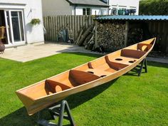 a wooden canoe sitting on top of green grass