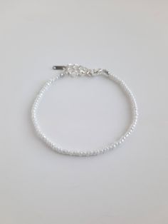 Pearly white seed bead bracelet with silver hardware 4 inch daisy chain with 1 inch extension: 5 inches total 5 inch daisy chain with 1 inch extension: 6 inches total 6 inch daisy chain with 1 inch extension: 7 inches total 7 inch daisy chain with 1 inch extension: 8 inches total Sterling Silver plated lobster clasp and extender Please message me if you would like a different size! Adjustable White Pearl Bracelet With Beaded Chain, White Beaded Chain Bracelet, Silver Beaded Minimalist Pearl Bracelet, Everyday White Bracelets With Spacer Beads, Everyday White Jewelry With Silver Beads, White Beaded Pearl Bracelet With Round Beads, White Beaded Chain Pearl Bracelet Gift, Everyday White Beaded Bracelets With Tiny Beads, White Beaded Pearl Bracelets