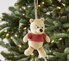 a teddy bear ornament hanging from a christmas tree