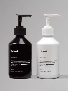 a bottle of hand soap next to a black and white container on a gray background