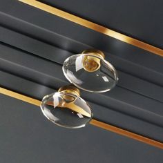 two glass door knobs with gold trim on them