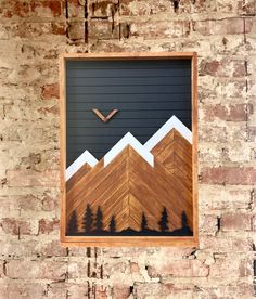 an image of mountains and pine trees on a brick wall with a clock in the middle