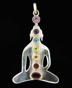 a silver pendant with seven chakras in the shape of a person's head