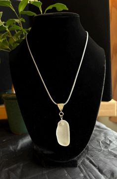 Discover the timeless allure of our thick curved frosted white pendant necklace, a unique piece of wearable art that embodies the beauty and tranquility of Lake Michigan. This exquisite pendant features genuine sea glass, meticulously handpicked from the shores of Lake Michigan and expertly handcrafted into a one-of-a-kind accessory. Specifications: -Pendant length:  around 1.5 inches -Amount of sea glass: 1 piece -Chain Length: 20" chord adjustable -Clasp:lobster claw  adjustable -Materials: Genuine Lake Michigan sourced Sea Glass,stainless steel nickel-free metal chain, wire, cord Features: -Authentic Lake Michigan Sea Glass: Carefully handpicked from the pristine shores of Lake Michigan, ensuring a one-of-a-kind piece that is never reshaped. When picking pairs we look for similarities b White Necklace With Large Pendant, Unique White Necklace With Large Pendant, Nickel-free White Oval Pendant Necklace, Minimalist Nickel-free White Necklace, Unique White Round Pendant Necklace, Minimalist White Nickel-free Necklace, Handmade White Glass Jewelry, White Oval Pendant Jewelry With Adjustable Chain, White Jewelry With Large Round Pendant