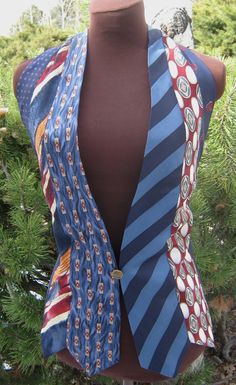 a mannequin wearing a blue vest with red, white and blue neck ties