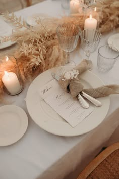 the table is set with white plates and silverware