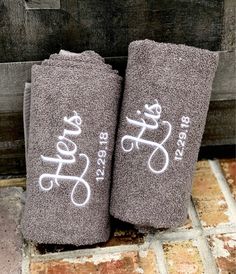 two personalized towels are sitting on the floor next to a brick wall and door