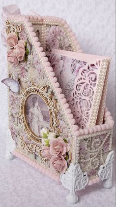 an ornate pink and white card holder with pictures on it's sides, decorated with flowers