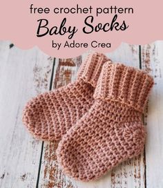 a pair of pink knitted baby socks sitting on top of a wooden floor with text overlay that says, free crochet pattern baby socks