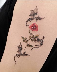 a rose and two birds on the back of a woman's shoulder with black ink