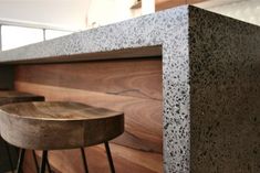 two wooden stools sitting next to a counter in a room with wood flooring