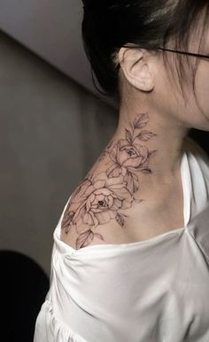 a woman with a flower tattoo on her neck