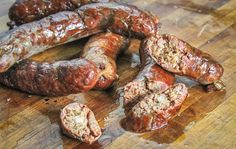 some sausages are on a wooden cutting board