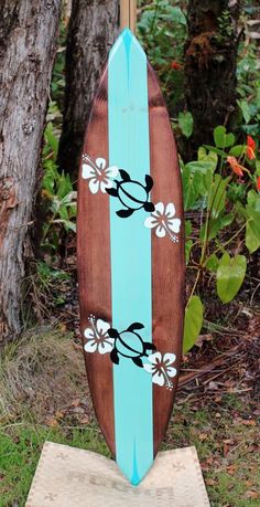 a wooden surfboard with flowers painted on it