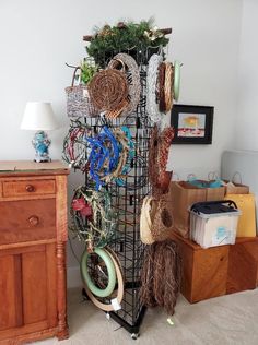 there is a rack with baskets and other items on the floor next to a dresser