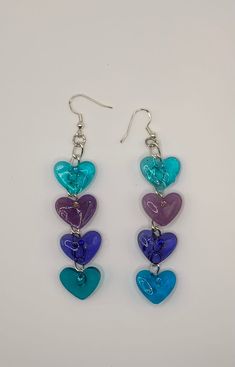 Clear colorful hearts make these whimsical earrings fun to wear. Lightweight and hypoallergenic. Whimsical Nickel-free Heart Earrings, Cute Multicolor Heart Charm Earrings, Cute Multicolor Earrings With Heart Charm, Purple Dangle Heart Earrings For Pierced Ears, Cute Multicolor Heart-shaped Jewelry, Trendy Dangle Heart Earrings With Ear Wire, Rainbow Heart Earrings For A Gift, Rainbow Heart-shaped Earrings As Gift, Heart-shaped Rainbow Earrings As Gift