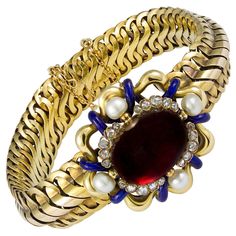 A Victorian garnet, diamond and pearl bracelet with a central cabochon-cut garnet measuring 18.5 x 14mm, surrounded by four sections of five rose-cut diamonds, total estimated weight approximately 0.36cts, spaced by four 5mm pearls, all within an openwork yellow gold and royal blue enamel border of stylised floral design, the bracelet section of yellow gold S-shaped links, integral clasp and safety chain, circa 1860, measuring approximately 18.5 x 3cm, gross weight 50.5 grams. This sumptuous bracelet from the collection of Bentley & Skinner, the London jewellers by appointment to both Her Majesty the Queen and His Royal Highness the Prince of Wales exemplifies high Victorian style. The heavy gold links feature a large central cabochon-cut garnet surrounded by diamonds, pearls, and vivid bl Gold And Royal Blue, Victorian Bracelet, Cameo Bracelet, Gold Pearl Bracelet, Locket Bracelet, Twisted Bracelet, Yellow Gold Bangle, Diamond Bangles Bracelet, Gold Locket