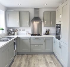 a kitchen with grey cabinets and white counter tops