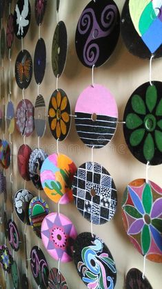 a wall covered in lots of different colored circles and shapes hanging from it's sides