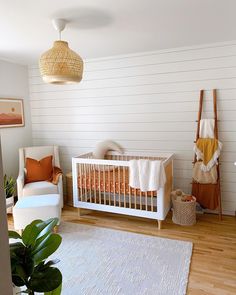 a baby's room with white walls and wood floors, including a crib