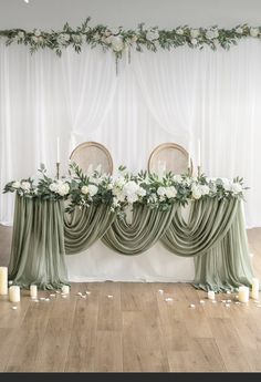 the table is set up with candles and greenery for an elegant touch to the room