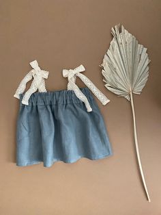 a doll is next to a fake palm leaf and it looks like she's wearing a skirt