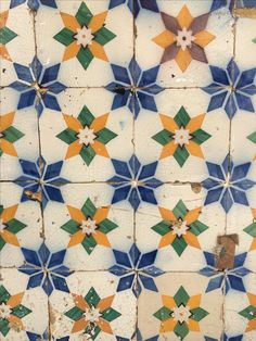 an old tiled wall with multicolored tiles on it