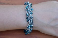 a woman's arm with a bracelet made out of silver and blue glass beads