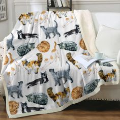 a blanket with cats on it sitting on a couch