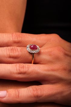 Center Stone: Cabochon Cut RubyWeight: Approximately 1.8 CaratAccent Stone: 13 Old Mine Cut DiamondsWeight: Approximately .50 CaratsColor: IClarity: SIMetal: 18K Yellow Gold and PlatinumEra: ModernCirca: 2020s in The Style of EdwardianSize: 7 and can be resizedGram weight: 3.5This elegant modern ring, crafted in the timeless style of Edwardian jewelry, features a captivating 1.8-carat cabochon cut ruby at its center. Surrounding the ruby are 13 sparkling old mine cut diamonds, totaling approxima Luxury Elegant Ruby Ring With Cabochon, Yellow Gold Cocktail Ring, Unique Rings Vintage, Edwardian Jewelry, Platinum Diamond Engagement Rings, Fancy Yellow Diamond, Edwardian Style, Gold Cocktail Ring, Gold Cocktail