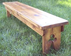 a wooden bench sitting on top of a lush green field