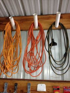 there are many different cords hanging on the wall with wires attached to them and some tools in front of them