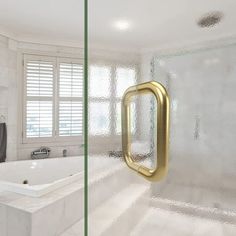 a bathroom with a large bathtub and a gold handle on the door in front of it