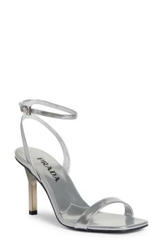 A sculptural heel with an iconic triangular Prada logo supports this minimalist ankle-strap sandal crafted of silvery calfskin leather. 3 1/4" (83mm) heel Adjustable strap with buckle closure Leather upper, lining and sole Made in Italy Designer Shoes Prada Women Shoes, Sleek Silver Heels With Sculpted Heel, Modern Silver Sandals With Padded Heel, Metallic Silver Heels With Ankle Strap, Sleek Silver Ankle Strap Heels, Sleek Silver Heels With Padded Heel, Modern Metallic Sandals With Sculpted Heel, Luxury Silver Sandals With Sculpted Heel, Modern Metallic Ankle Strap Heels