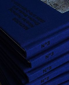 a stack of blue books sitting on top of a wooden table