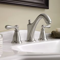 a bathroom sink with two faucets and soap dispenser