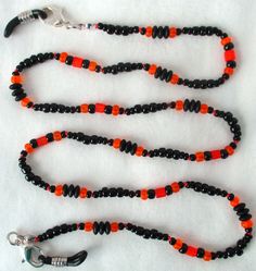 You'll always keep track of your reading glasses when using this orange & black beaded eyeglass chain! 25" in length, made with glass beads, beading cord, metal lobster clasps, and adjustable rubber holders. Lobster clasps make it easy to change the rubber holders, and an extra pair of holders included with every purchase. This orange & black beaded eyeglass chain will arrive in a gift box, ready to give as a present or to keep and store. Back to Beaded Eyeglass Chains Black Glass Beaded Necklaces With Colorful Beads, Black Glass Beaded Necklace With Colorful Beads, Black Glass Beaded Necklaces With Beaded Chain, Black Glass Beaded Necklace With Beaded Chain, Black Jewelry With Colorful Czech Glass Beads, Black Glass Beaded Necklace, Adjustable Orange Necklaces With Black Beads, Adjustable Orange Necklace With Black Beads, Adjustable Czech Glass Beaded Necklaces With Lobster Clasp