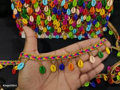 a hand holding a multicolored bracelet with lots of beads on it's wrist