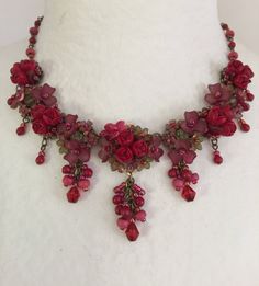 Roses are Red Necklace is so romantic. With several clusters of flowers and a poise of red roses in the center of each. This necklace is a gorgeous stunning red with a hints of green flowers that compliments the red. This piece is set off nicely with pretty red drops hanging off of each cluster. Every one needs a stunning statement red necklace in their collection. Colleen has been creating her unique style of vintage jewelry for more than 30 years. All of our pieces come with an engraved tag wi Red Rose Design Necklace For Wedding, Red Rose Jewelry For Wedding, Pretty Valentines, Roses Are Red, Red Necklace, Valentines Necklace, Clay Flowers, Etsy Jewelry, Green Flowers