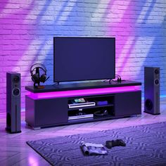 an entertainment center with speakers and a television on it in front of a brick wall