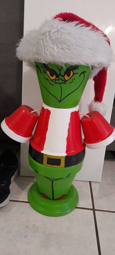 an inflatable christmas decoration with a santa hat and grino costume on the floor