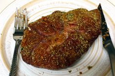 a piece of meat on a plate with a fork and knife