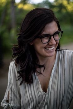 a woman wearing glasses and smiling for the camera